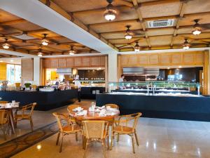 a dining room with tables and chairs and a kitchen at Fiesta Americana Puerto Vallarta All Inclusive & Spa in Puerto Vallarta