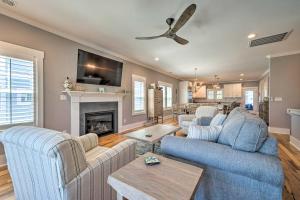 a living room with two blue couches and a fireplace at Bright Coastal Abode with Porch and Beach Access! in Carolina Beach