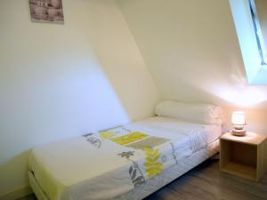 a small bed in a small room with a lamp at Cottage, Beuzec Cap Sizun in Beuzec-Cap-Sizun