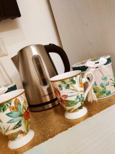 - un comptoir avec 2 tasses et une bouilloire dans l'établissement SUITE ROMA, à Cefalù