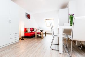 a living room with a table and a red couch at Budget Apartment Köln in Cologne