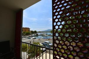 a room with a balcony with a view of a marina at AMBRA HOTEL - The only central lakeside hotel in Iseo in Iseo