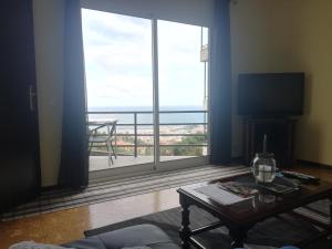 un soggiorno con una grande finestra con vista sull'oceano di House Joel & Sonia with sea view a Funchal