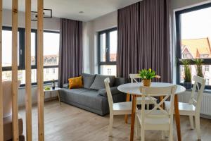 a living room with a couch and a table at Office Park Aparthotel in Toruń
