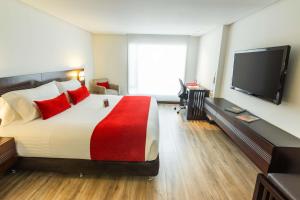 ボゴタにあるBest Western Plus 93 Park Hotelのベッドと薄型テレビがあるホテルの部屋