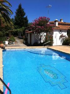 una gran piscina azul frente a una casa en La Caldera Vieja, en Zalamea la Real