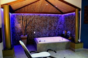 uma grande casa de banho com uma banheira com iluminação roxa em MOTEL COPACABANA em Ribeirão Preto