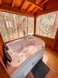 a white tub in a room with two windows at Domos Sup3r López in Pesca