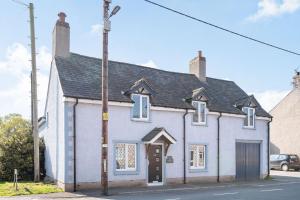 a white house with a black roof on a street at The Old Nags Head in Ruthin