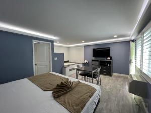 a bedroom with a bed and a desk and a television at Deluxe Inn Hawthorne/ LAX in Hawthorne