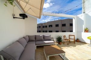 un soggiorno con divano e un tavolo sul balcone. di Un Lugar House Canteras - Coliving a Las Palmas de Gran Canaria