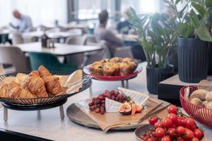 a table topped with plates of bread and pastries at Radisson RED, Oslo Airport in Gardermoen