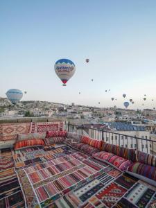 a group of hot air balloons flying over a city at Avlu Cave House in Göreme