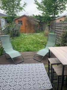 3 chaises et une table sur une terrasse en bois dans l'établissement Studio cosy à 10 minutes de Disneyland Paris, à Bailly-Romainvilliers