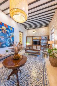 una sala de estar con una mesa y un sofá en FREE PRIVATE PARKING Casa Trova en Santa Lucía Centro Mérida, en Mérida
