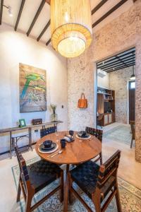 a dining room with a wooden table and chairs at FREE PRIVATE PARKING Casa Bolero en Santa Lucía Centro Mérida in Mérida +2 photos