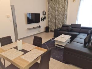 a living room with a table and a couch at Appartement t2 calme spacieux Saint-Étienne bellevue in Saint Etienne