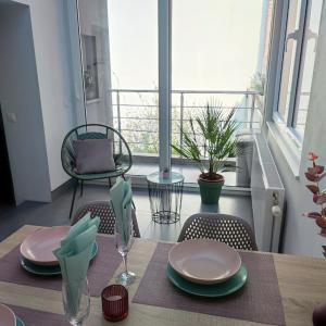 einen Tisch mit Tellern und Stühlen auf dem Balkon in der Unterkunft Apartment Villa Ksenija in Ostende