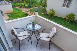 a balcony with a table and two chairs and a garden at Apartments KOVAC in Tivat