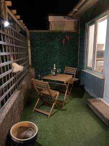a patio with a table and two chairs and a window at Poolside in Peacehaven