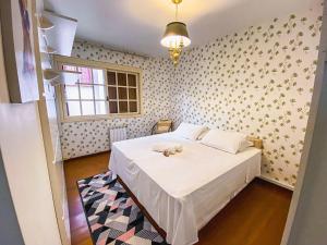 a bedroom with a bed and a wall with flowers at LOCAR-IN GRAMADO - Apartamento Rua Torta in Gramado