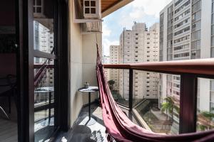 un balcón con hamaca y vistas a la ciudad en Apartamento Jardins Boutique, en São Paulo