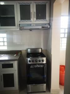 a kitchen with a stove and white cabinets at pié de la montaña 2 in Bonao