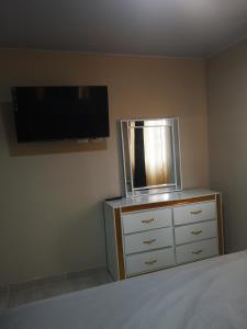 ein Schlafzimmer mit einer Kommode und einem Flachbild-TV in der Unterkunft pié de la montaña 2 in Bonao