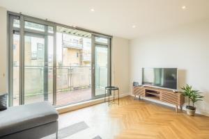 a living room with a large window and a flat screen tv at EXECUTIVE 2BR apartment next to Station + Parking in Cambridge