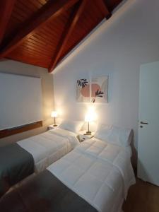 two beds in a hotel room with two lamps at BE MAISON USHUAIA in Ushuaia