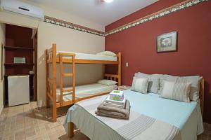 1 dormitorio con 2 literas y 1 cama con toallas en Pousada Rota das Cachoeiras, en Patrimônio São Sebastião