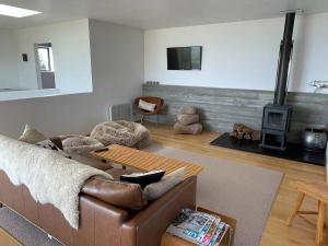 a living room with a couch and a wood stove at The Cube in Kakanui