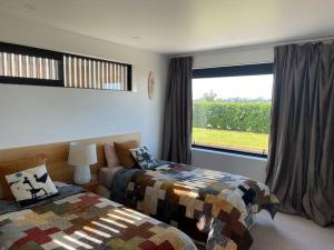 a bedroom with two beds and a large window at The Cube in Kakanui