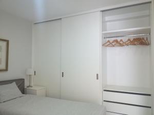 a white bedroom with a bed and a closet at H2O Porto Ribeira in Porto