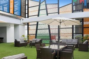 莫士比港的住宿－Crowne Plaza Residences Port Moresby, an IHG Hotel，庭院配有桌椅和遮阳伞。