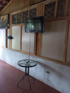 einen Tisch in einem Zimmer mit einem TV an der Wand in der Unterkunft Hotel y Bungalows ecologicos Marcelo in Santiago Atitlán