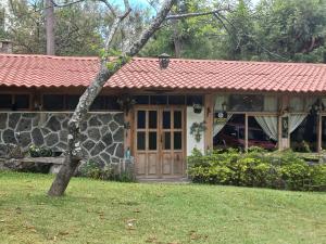 a house with a red roof and a yard at Hotel y Bungalows ecologicos Marcelo in Santiago Atitlán