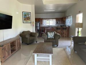 a living room with couches and a tv and a kitchen at Westmore Beach Villas Limited in Whitehouse