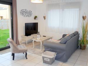 a living room with a couch and a tv at Beachfront holiday home, Guisseny in Guissény
