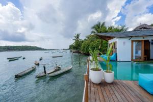 a house on a dock with boats in the water at Indigo Blue Ceningan in Nusa Lembongan