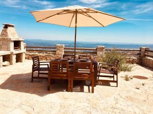 een houten tafel met een parasol en stoelen bij Mountain Chalet in Covilhã