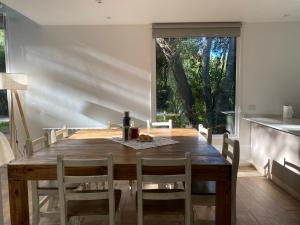 Casa del Bosque في سان كارلوس دي باريلوتشي: غرفة طعام مع طاولة وكراسي خشبية