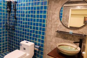 a bathroom with a toilet and a sink and a mirror at Young Coconut Garden Home Resort in Amphawa +35 photos