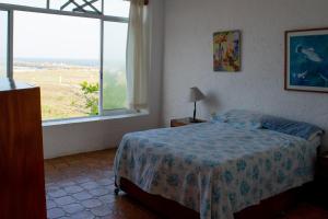ein Schlafzimmer mit einem Bett und einem großen Fenster in der Unterkunft Casa Roja, Tecolutla (frente al mar) in Tecolutla