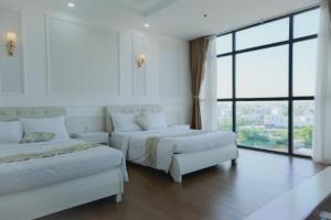 1 dormitorio con 2 camas y ventana grande en Linh Phuong 6 Hotel, en Can Tho