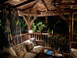 a living room with a couch on a porch at Rêve Et Alizé in Bouillante