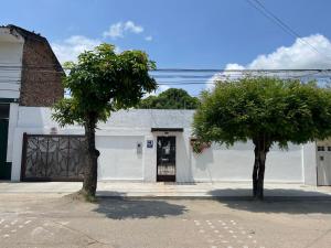 zwei Bäume vor einem weißen Gebäude in der Unterkunft Kalathea Casa in Tocaima