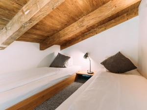2 łóżka w pokoju z drewnianym sufitem w obiekcie Tauern Lodge XL w mieście Piesendorf