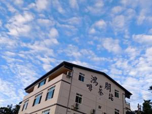 a building with asian writing on the side of it at Hongpeng Coffee Station Homestay in Meishan