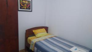 ein kleines Bett in einer Ecke eines Zimmers in der Unterkunft BACHÍG Hospedaje in Moyobamba
